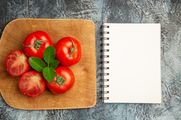 Foto gratuita vista superior de tomates rojos frescos con bloc de notas