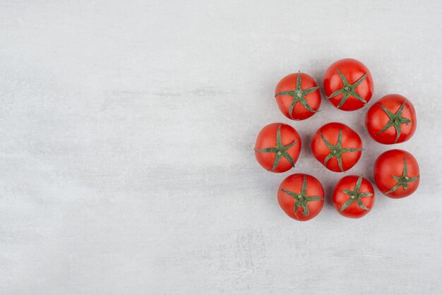 Vista superior de tomates rojos sobre fondo blanco.