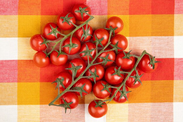 Vista superior de tomates en superficie de tela escocesa