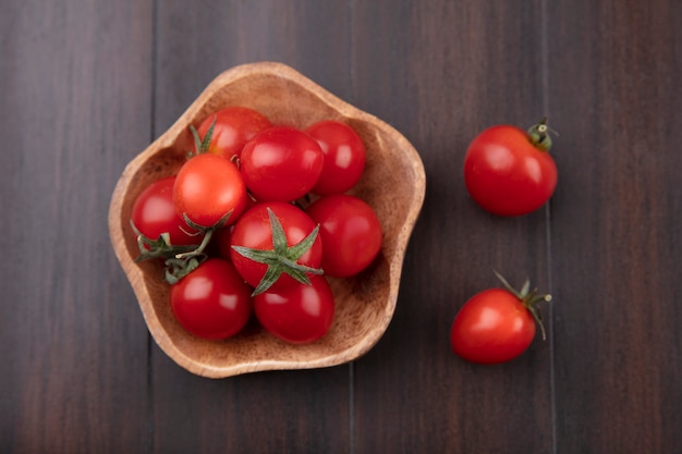 Vista superior de tomates en un tazón sobre superficie de madera