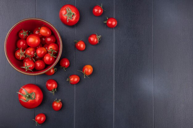 Vista superior de tomates en un tazón y sobre una superficie negra