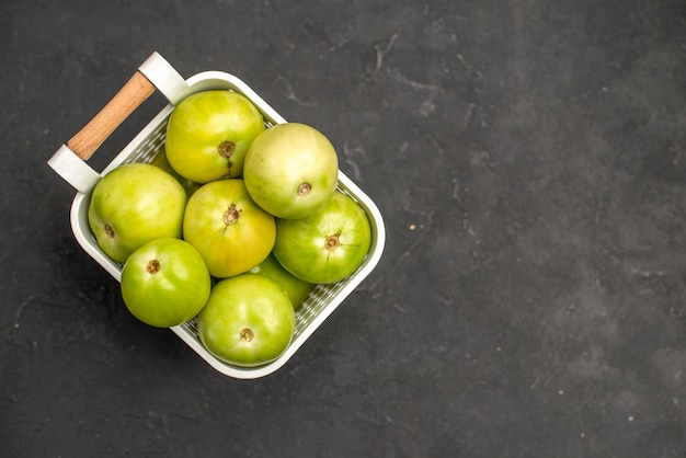 Foto gratuita vista superior de tomates verdes dentro de la cesta sobre fondo oscuro