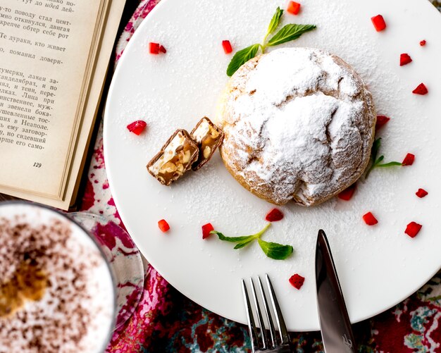 Vista superior de la torta de masa de mantequilla decorada con fresas cortadas en un plato blanco