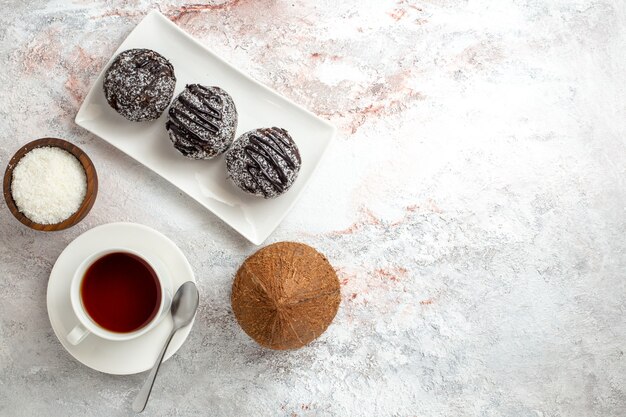 Vista superior de tortas de chocolate con taza de té sobre fondo blanco pastel de chocolate galleta galletas dulces de azúcar