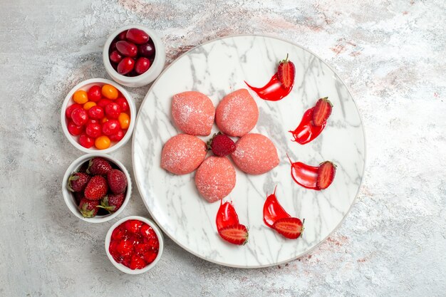 Vista superior tortas de fresa rosa con frutas sobre fondo blanco pastel de azúcar galleta té galleta dulce