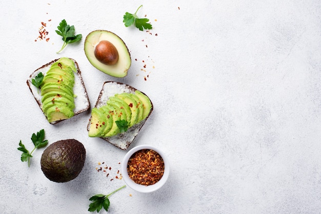 Vista superior de tostadas de aguacate para el desayuno con hierbas y especias.