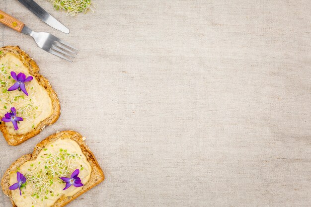 Vista superior de tostadas con cubertería y espacio de copia