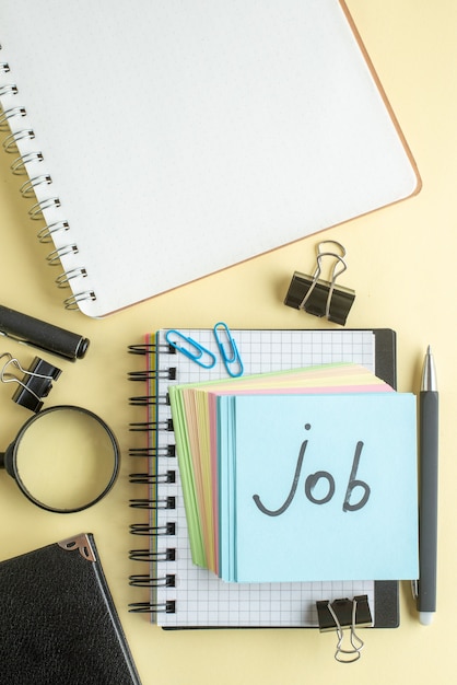 Foto gratuita vista superior trabajo nota escrita junto con pequeñas notas de papel de colores sobre fondo claro bloc de notas bolígrafo oficina escolar cuaderno trabajo negocio dinero trabajo en color