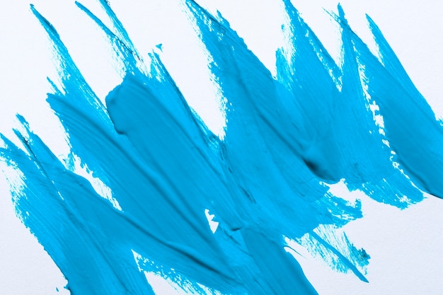 Vista superior de trazos de pincel de pintura azul en la superficie