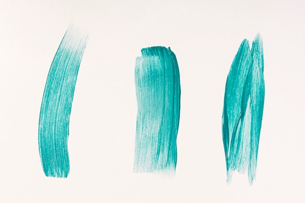 Vista superior de tres trazos de pincel de pintura azul