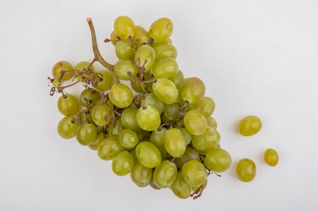 Vista superior de uva blanca sobre fondo blanco.