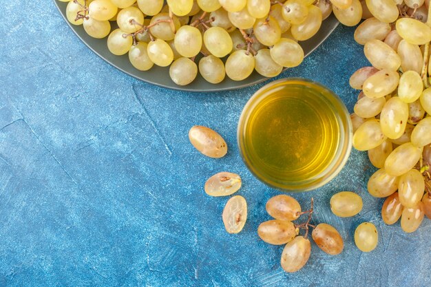 Vista superior de uvas frescas en una mesa azul