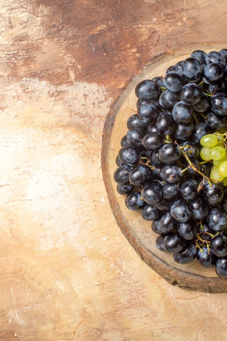 Foto gratuito vista superior de las uvas uvas verdes y negras en el tablero de la cocina