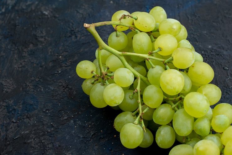 Foto gratuito una vista superior de uvas verdes frescas agrias jugosas y suaves en el fondo oscuro planta madura de frutas