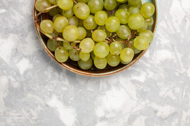 Vista superior de uvas verdes frescas jugosas frutas dulces suaves sobre superficie blanca
