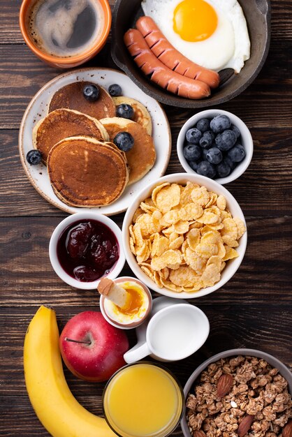 Vista superior de la variedad de alimentos para el desayuno con leche y jugo de naranja.