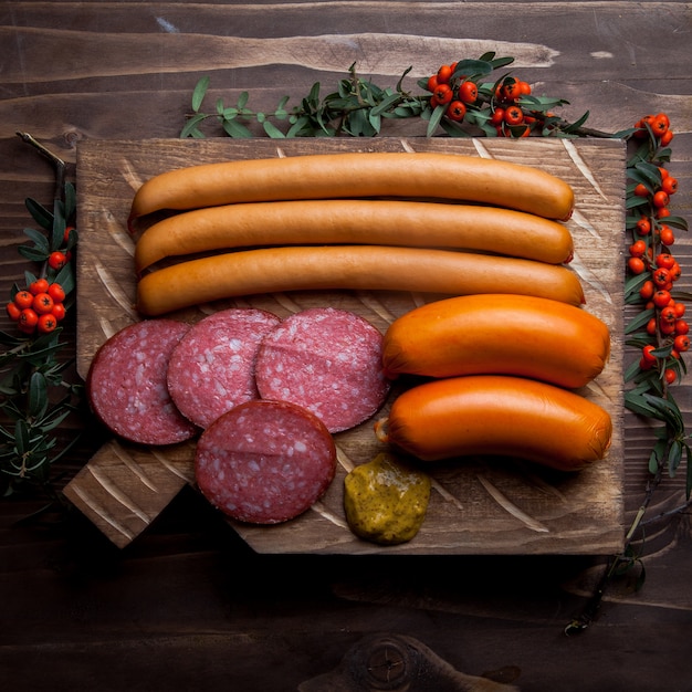 Foto gratuita vista superior de una variedad de salchichas con serbal y mostaza en utensilios de cocina