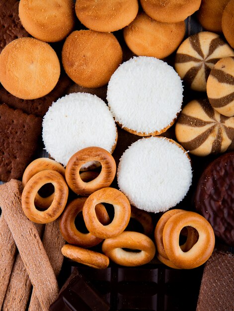Vista superior de varios dulces galletas de chocolate anillos de pan como fondo