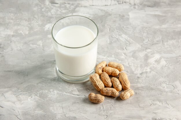 Vista superior del vaso lleno de leche y frutos secos sobre fondo de hielo