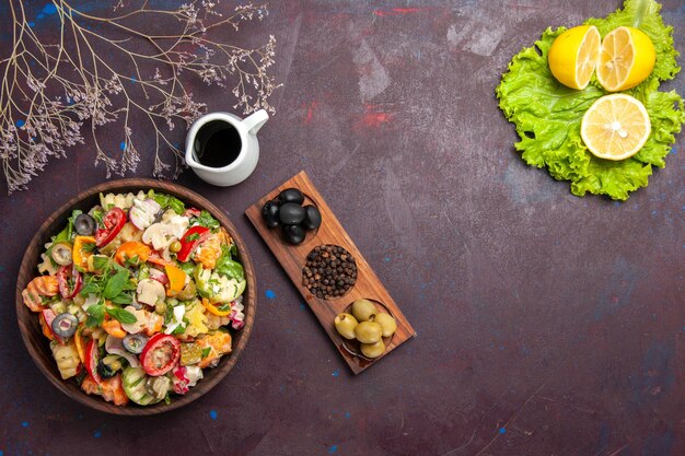 Vista superior de vegetales frescos. Ensalada con aceitunas y rodajas de limón sobre negro