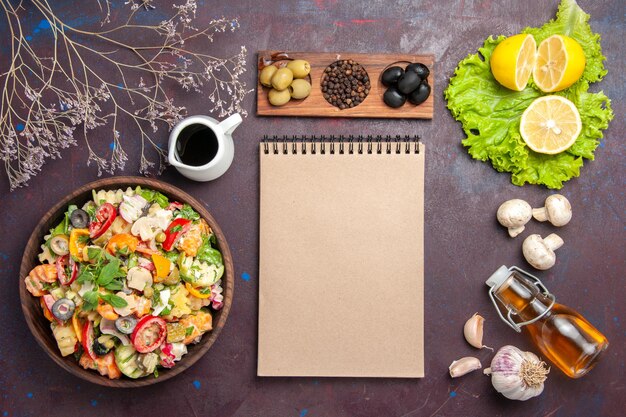 Vista superior de vegetales frescos. Ensalada con aceitunas y rodajas de limón sobre negro