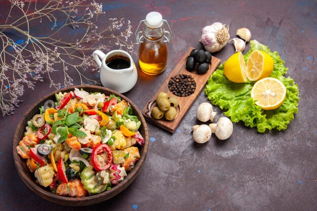 Vista superior de vegetales frescos. Ensalada con aceitunas y rodajas de limón sobre piso negro ensalada de alimentos dieta snack salud