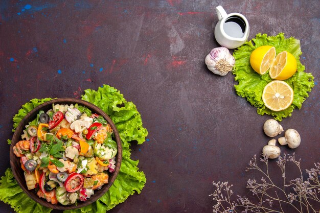 Vista superior de vegetales frescos. Ensalada con rodajas de limón y ensalada verde sobre negro