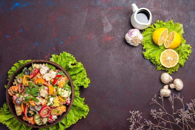 Vista superior de vegetales frescos. Ensalada con rodajas de limón y ensalada verde sobre negro