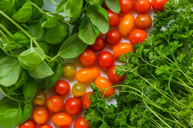 Vista superior de verdes con tomates en la superficie blanca. horizontal