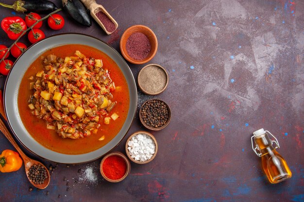 Vista superior de verduras cocidas en rodajas con salsa y condimentos sobre fondo oscuro comida salsa comida cena sopa vegetal