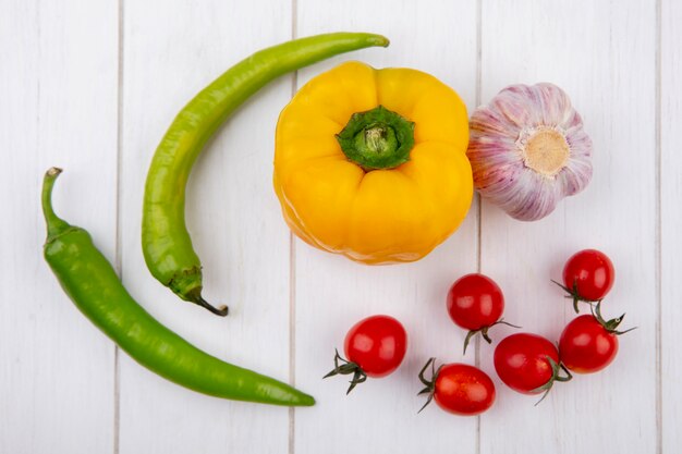 Vista superior de verduras como pimiento ajo tomate en superficie de madera