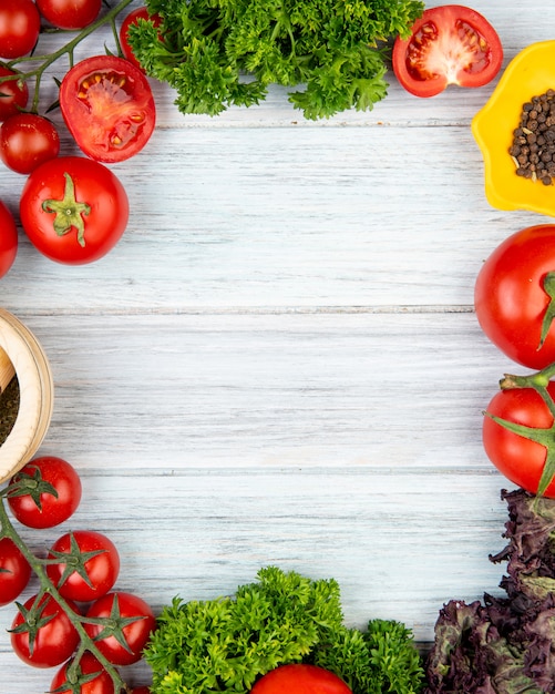 Foto gratuita vista superior de verduras como tomate cilantro albahaca con pimienta negra trituradora de ajo sobre superficie de madera con espacio de copia