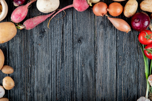 Vista superior de verduras como tomate rábano cebolla patata sobre fondo de madera con espacio de copia