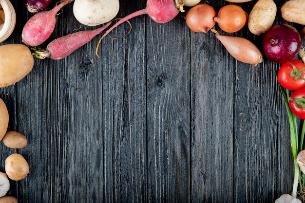 Vista superior de verduras como tomate rábano cebolla patata sobre fondo de madera con espacio de copia