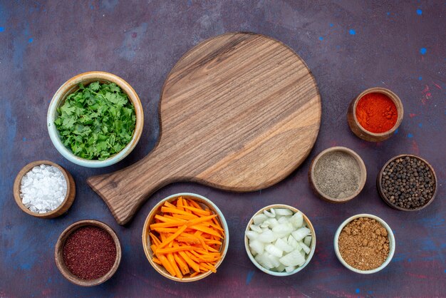 Vista superior de verduras y condimentos con cebollas en rodajas en el escritorio oscuro ensalada comida comida vegetal snack