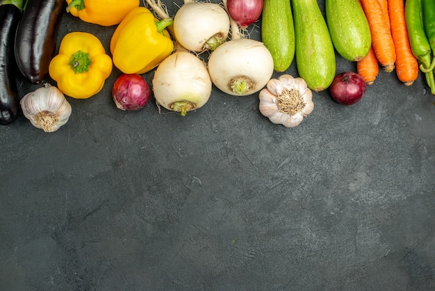 Foto gratuita vista superior de verduras frescas berenjenas pimientos y otras verduras sobre un fondo oscuro