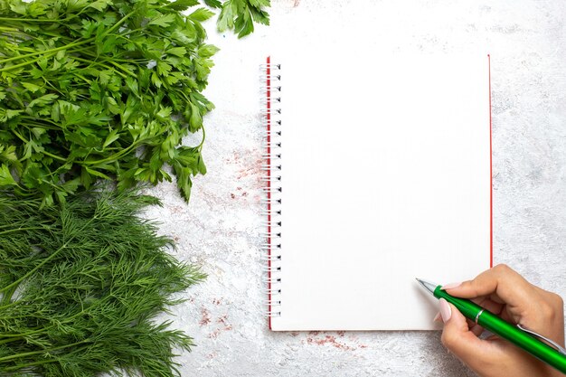 Vista superior de verduras frescas con bloc de notas en la superficie blanca comida de comida de producto verde