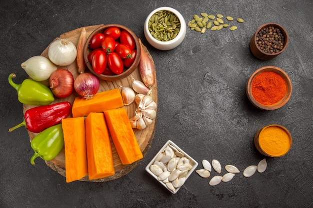 Vista superior de verduras frescas con calabaza y condimentos en el color de comida madura de ensalada de fondo oscuro