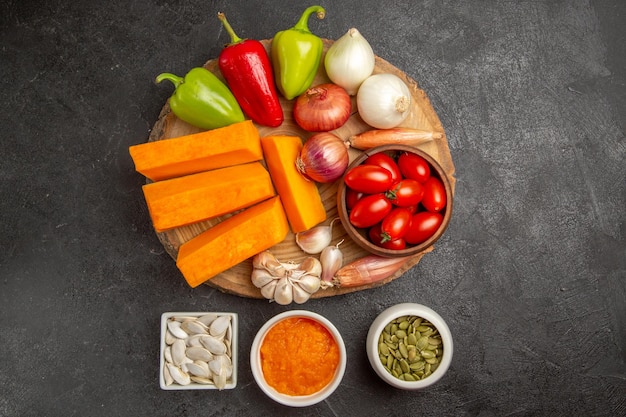 Vista superior de verduras frescas con calabaza en rodajas en la ensalada madura de semillas frescas de color de fondo gris