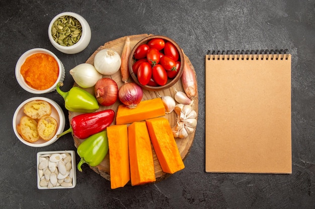 Vista superior de verduras frescas con calabaza y semillas en el color de comida madura de ensalada de fondo oscuro