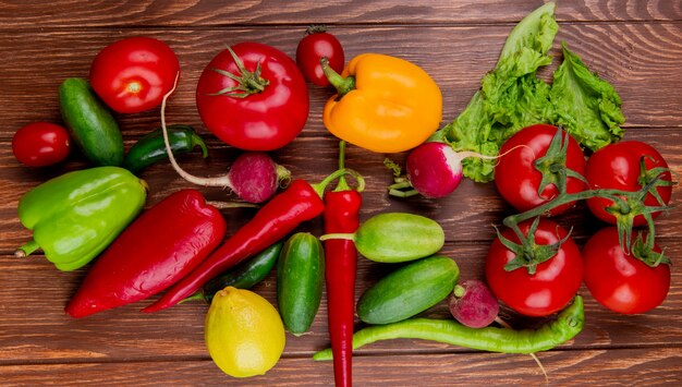 Vista superior de verduras frescas coloridos pimientos rábano pepinos tomates chiles rojos y lechuga en madera rústica