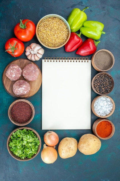 Foto gratuita vista superior de verduras frescas con condimentos, carne y verduras en la superficie azul oscuro
