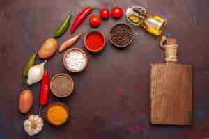 Foto gratuita vista superior de verduras frescas con diferentes condimentos en el espacio oscuro