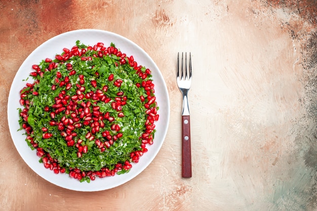 Vista superior de verduras frescas con granadas peladas en la mesa de luz comida de color verde de fruta