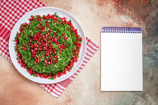 Vista superior de verduras frescas con granadas peladas en mesa de luz comida verde de frutas