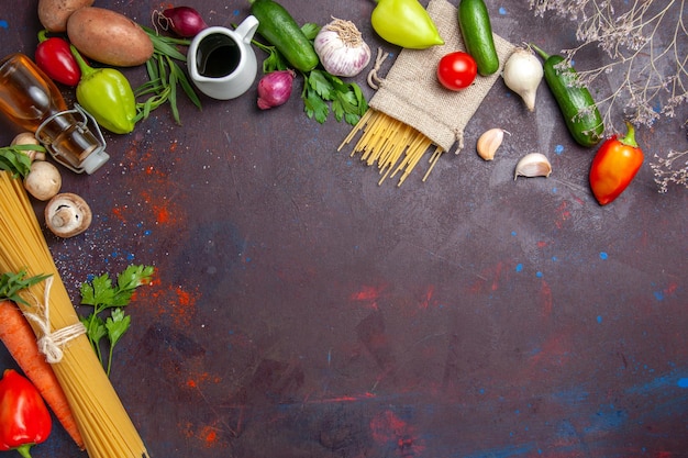 Vista superior de verduras frescas con pasta cruda en la superficie oscura ensalada de comida madura