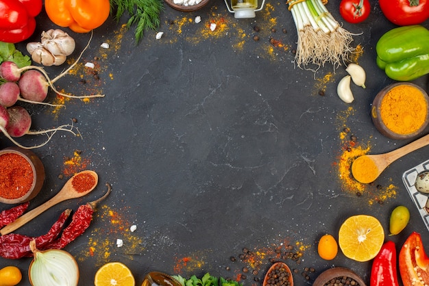 Vista superior de verduras frescas, pimiento rojo en polvo y cúrcuma en tazones pequeños, cucharas de madera en el espacio libre de la mesa