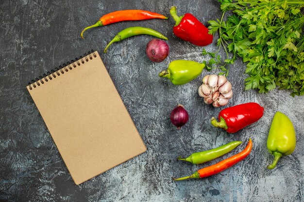 Vista superior de verduras frescas con pimientos y ajo en la mesa gris claro