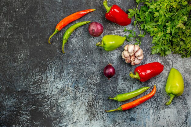 Vista superior de verduras frescas con pimientos y ajo en la mesa gris claro