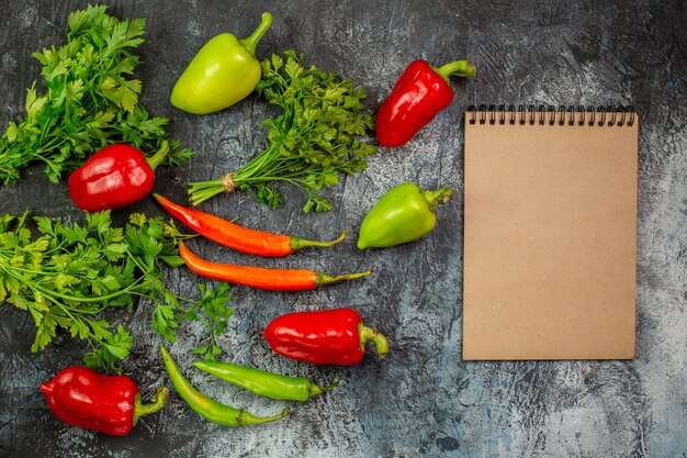 Vista superior de verduras frescas con pimientos en la mesa gris claro